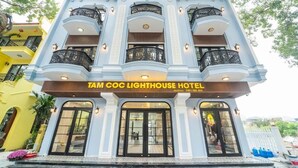 Un edificio a più piani con balconi, un cartello con la scritta “Tam COC Lighthouse Hotel” e una facciata ben tenuta.