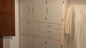 A room with a large wardrobe, a wooden door, and a towel hanging on a rack.