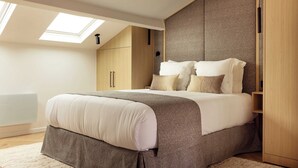 Ein Schlafzimmer mit Bett, Oberlicht, Kleiderschrank und Heizkörper.