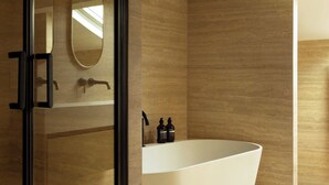 Ein modernes Badezimmer mit einer freistehenden Badewanne, einem großen Spiegel und einem eleganten Design.