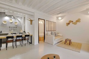 Een modern interieur met een eethoek, een bank en decoratieve wandkunst.