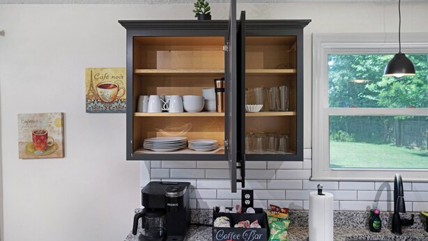 A kitchen with a dark wooden cabinet, a coffee maker, and a window with a view of greenery. - Carbon Ridge 300mbps WiFi - Dog Friendly (Clarksville)