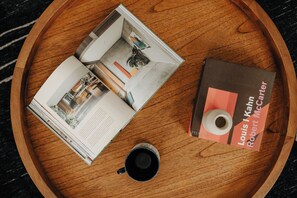 A wooden tray with a book titled 'Louis Kahn Robert McCarter', a black mug, and a magazine with interior design images. - Onyx Ridge · Breathtaking Views · 14 Acres (Jeffersonville)