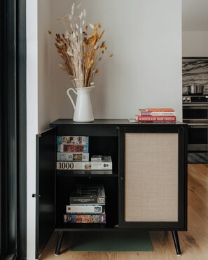 A black bookshelf with a white vase of dried flowers on top, a small stack of books, and a woven basket. - Onyx Ridge · Breathtaking Views · 14 Acres (Jeffersonville)