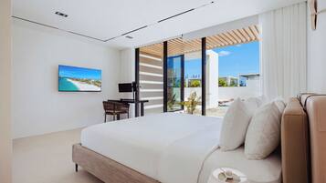 Un dormitorio moderno con una cama grande, un escritorio y vistas al exterior.