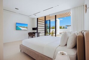 Un dormitorio moderno con una cama grande, un escritorio y vistas al exterior.
