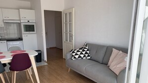 Ein kompakter Wohnbereich mit Küchenzeile, Essplatz und Sofa.