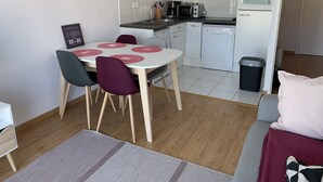 Eine kleine Küche mit weißen Schränken, einer Mikrowelle, einem Toaster und einem Geschirrspüler.