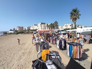 Ein Markt direkt am Strand mit Ständen, an denen Kleidung und Accessoires verkauft werden.