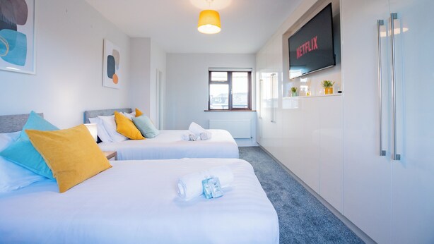 Une chambre d’hôtel avec deux lits, une télévision et une fenêtre.