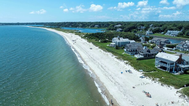 A coastal area with a sandy beach, houses, and a body of water. - Waterfront, Walk to Beach! (Barnstable)