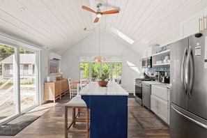A modern kitchen with a large island, stainless steel appliances, and a view to the outdoors. - Private Hot Tub, Near Dennis Pond (Yarmouth)