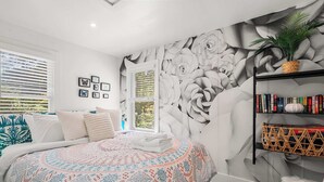 A bedroom with a large bed, a wall mural, a bookshelf, and a window with blinds. - Adorable Updated Cottage, Walk to Water! (Yarmouth)