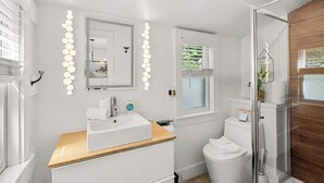A modern bathroom with a vanity, mirror, and lights. - Adorable Updated Cottage, Walk to Water! (Yarmouth)