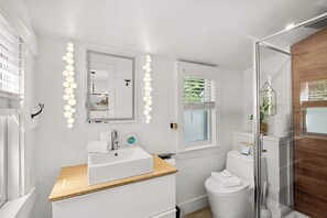 A modern bathroom with a vanity, mirror, and lights. - Adorable Updated Cottage, Walk to Water! (Yarmouth)