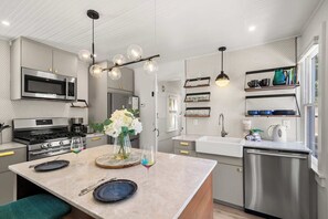 A modern kitchen with a central island, stainless steel appliances, and pendant lighting.