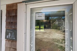 Eine Holzausfachung mit einem Schild, das 'Willkommen' verkündet, und einem Schild mit der Aufschrift 'Delmar Vacation Rentals' in einem Fenster.