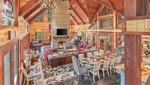 A spacious loft-style room with a fireplace, dining area, and seating.