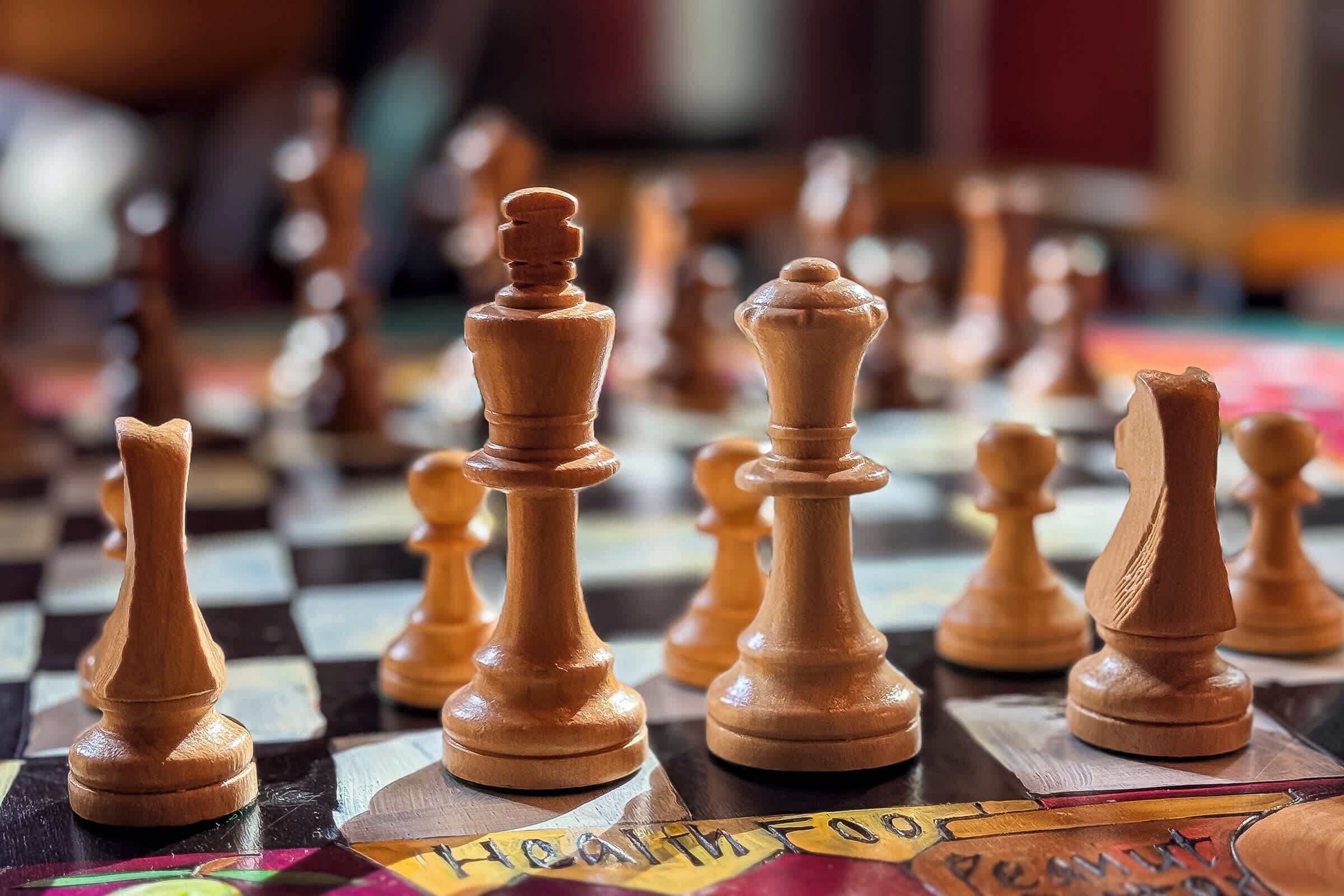 A chessboard with wooden chess pieces.