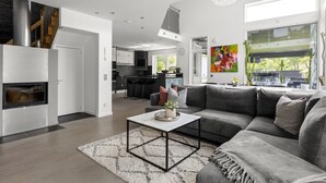 A modern living room with a gray sectional sofa, a coffee table, and a fireplace.