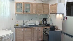 A modern kitchen with wooden cabinets, a stainless steel stove, and a refrigerator.