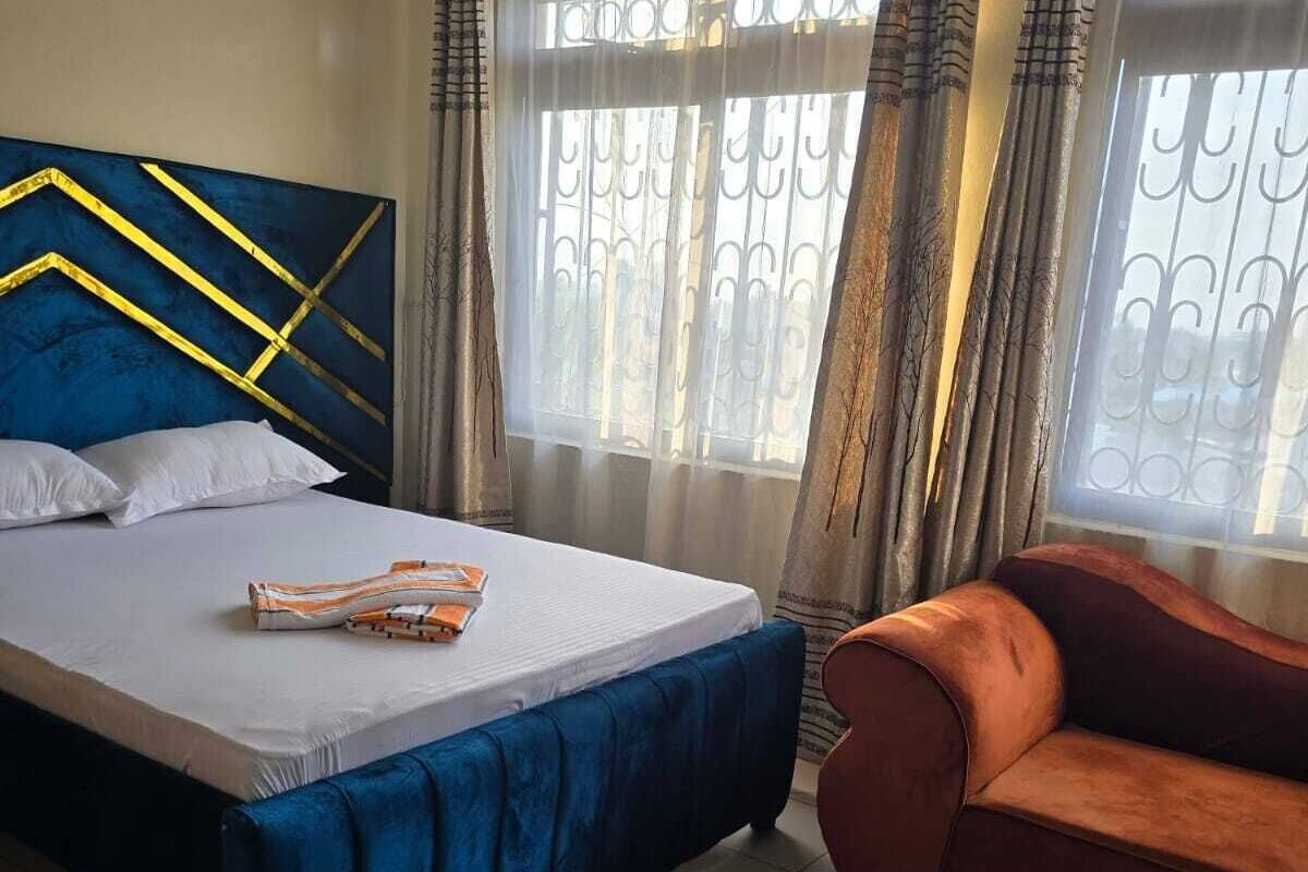 Un dormitorio con una cama, un sofá y una pequeña mesa.