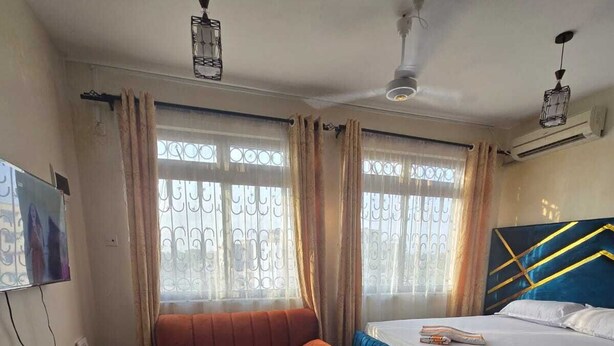 Een hotelkamer met een bed, een bank, een klein rond tafeltje en een televisie.