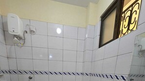 Een kleine badkamer met toilet, wastafel en douche.