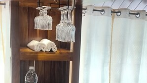 Un buffet proposant divers plats, une bouteille d’eau et de la verrerie décorative, le tout disposé sur un comptoir en bois.