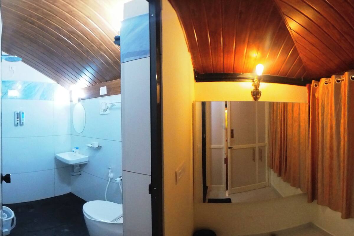 Casa de banho com sanita, lavatório e zona de duche.