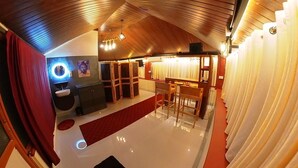 Une pièce avec un plafond en bois, un miroir rond, un petit lavabo et une moquette rouge.