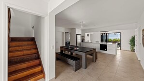 A modern kitchen with a dining table, a built-in bench, and a view of the outdoors.