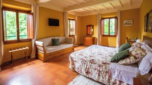A bedroom with a bed, a sofa, a dresser, and a window. - Albergo Villa San Michele  (Greve in Chianti)