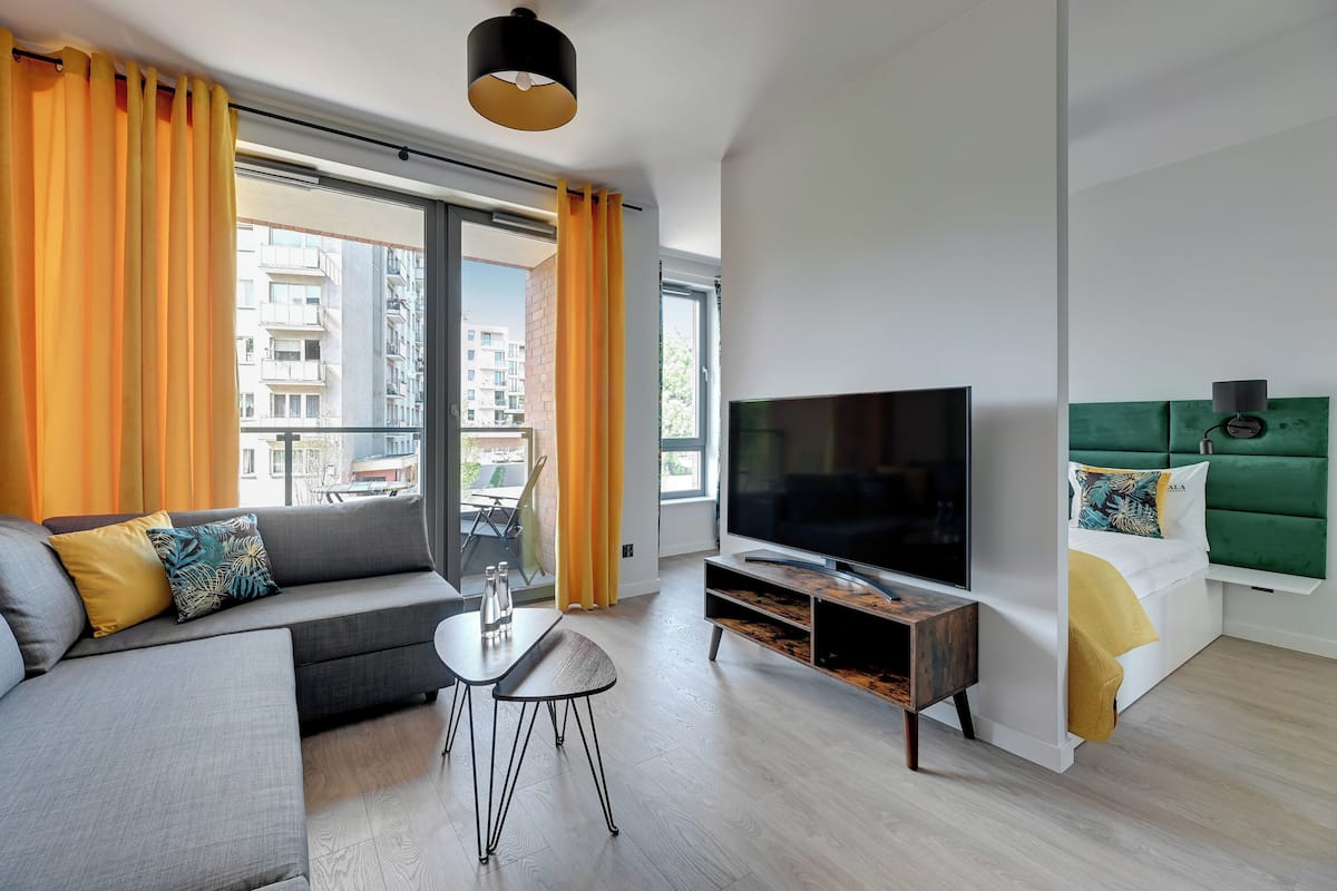 A modern living room with a sofa, TV, and a small table.