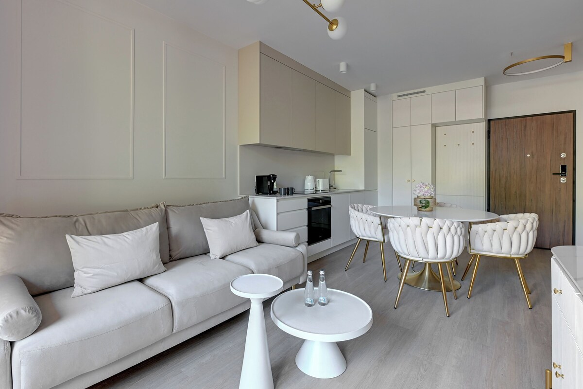 Una sala de estar moderna con un sofá, una mesa de centro y una mesa de comedor con sillas.