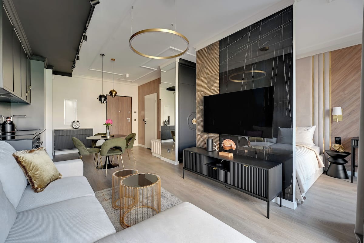 A modern living room with a sofa, a dining area, and a TV.