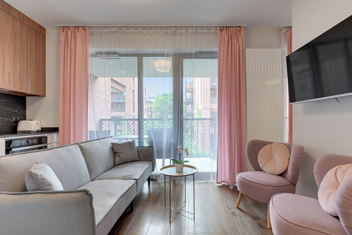 Una sala de estar moderna con un sofá, un sillón y una mesita con una planta.