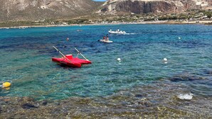 A clear blue sea with boats, a mountain, and a coastal town in the background. - The houses of the Piazzetta - Apartment Levanzo (Trapani)