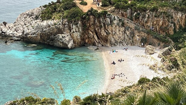 A coastal area with a rocky cliff, a beach, and a building with a pathway leading up to it. - The houses of the Piazzetta - Apartment Levanzo (Trapani)