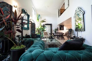 Ein geräumiger Wohnbereich mit Sofa, Couchtisch und Topfpflanzen.
