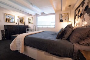 Una camera da letto con un letto grande, una cassettiera e una finestra vista.