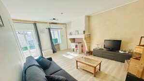 Una sala de estar moderna con un sofá, una mesa de centro, un televisor y una chimenea.