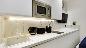 A modern kitchen with a built-in microwave, a coffee maker, and a toaster on the counter. - Modern Studio with AC in the heart of Paris (Paris)