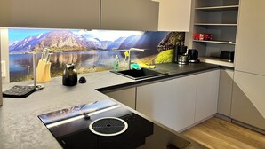 Une cuisine moderne dotée d’une grande fenêtre, d’une cuisinière encastrée et d’une machine à café.