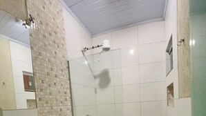 A bathroom with a sink, toilet, and shower. - Hotel Contagem (Sobradinho II)