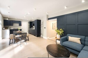 Relax in this stylish living space with a sofa, dining area, and fully equipped kitchen.