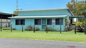 A two-story building with a sign indicating it is a holiday rental. - Perfect Fishing Holiday (Burrum Heads)