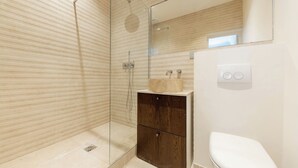 A modern bathroom with a glass shower enclosure, a wooden vanity, and a white toilet. - Trevise (Paris)
