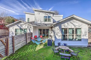 Enjoy a spacious backyard with a well-maintained lawn and outdoor seating options, including a dining table and chairs.