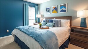 Een slaapkamer met een bed, nachtkastjes en wanddecoratie.